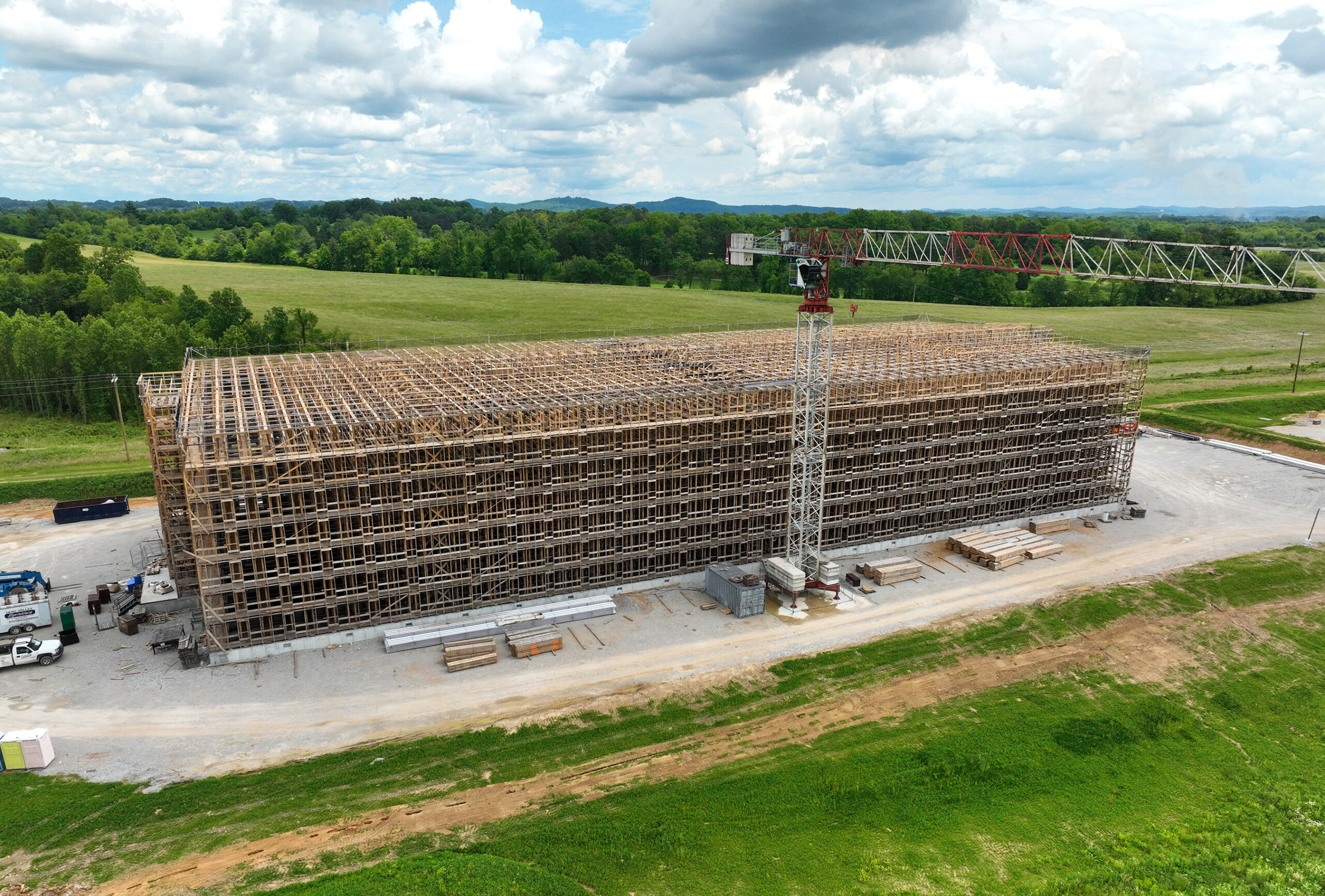 Large rickhouse bourbon barrel storage warehouse under construction with wood framing and large crane